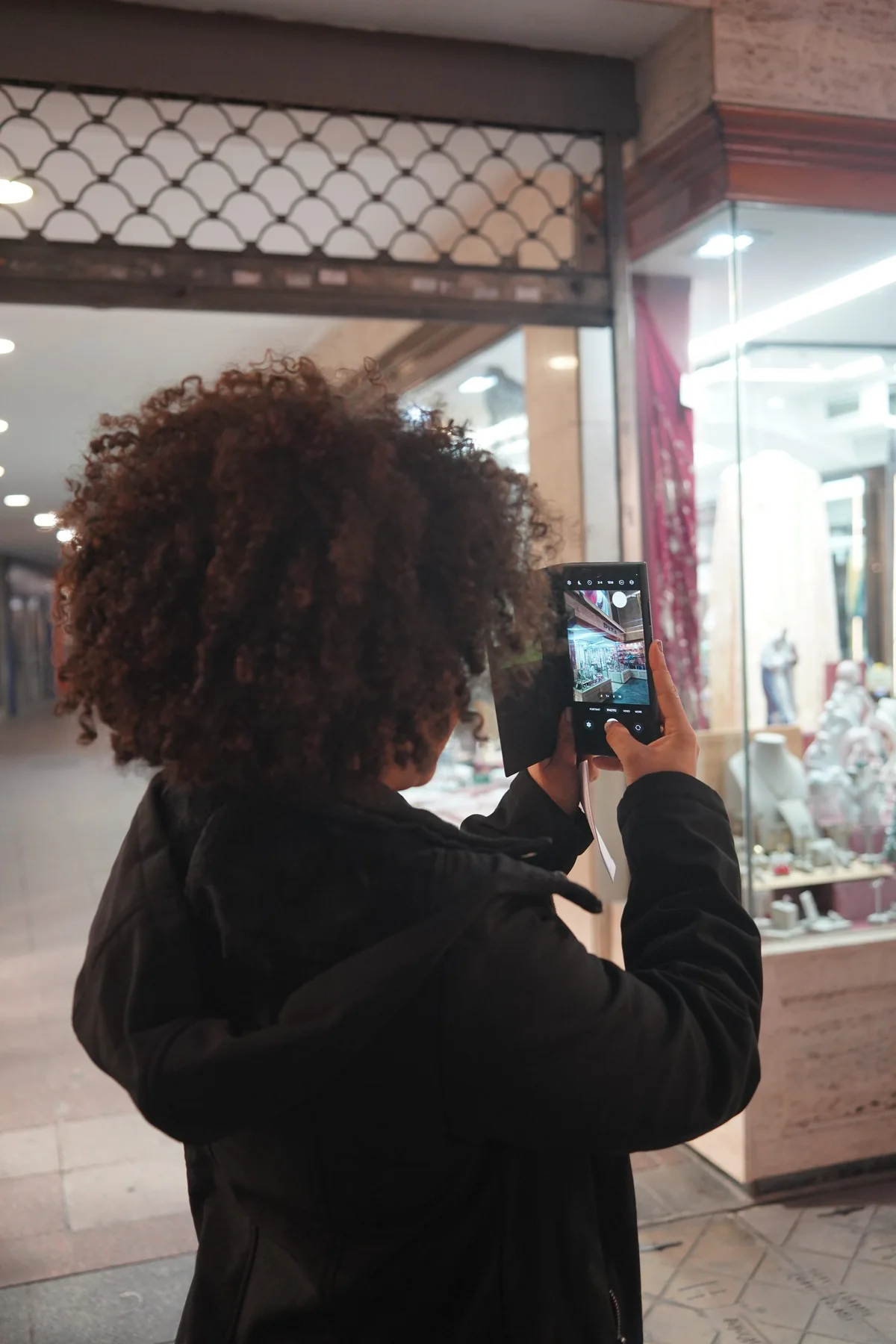 Representative customer using a phone while viewing shops